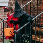 Fairy Garden - Kids in Halloween costumes with orange buckets going down on front steps of red brick house