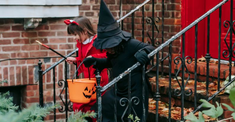 Fairy Garden - Kids in Halloween costumes with orange buckets going down on front steps of red brick house