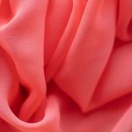 Fabric Dye - Background of from above of bright light pink satin uneven wrinkled textile with soft texture