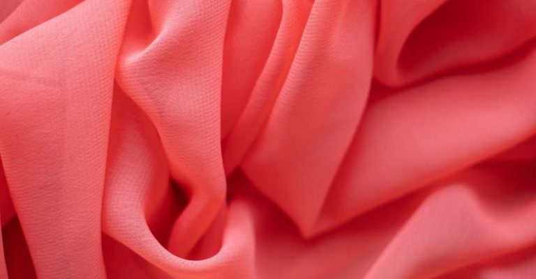 Fabric Dye - Background of from above of bright light pink satin uneven wrinkled textile with soft texture