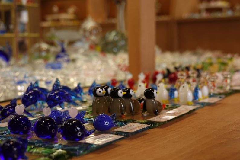 Crafting Jewelry - a group of glass figurines sitting on top of a wooden table