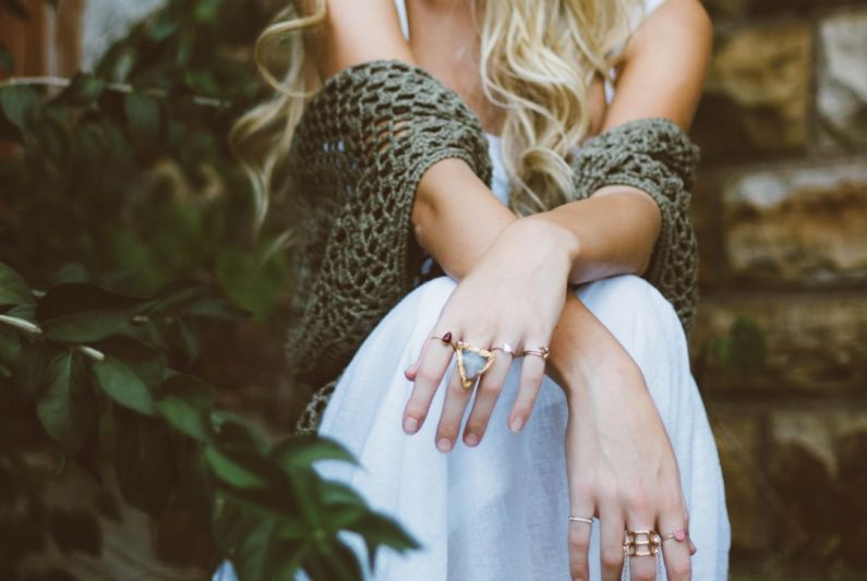 Silver Jewelry - woman sitting beside plant and concrete wall