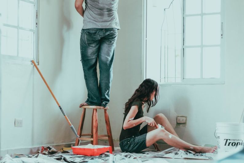 DIY - woman in gray tank top and blue denim jeans sitting on bed