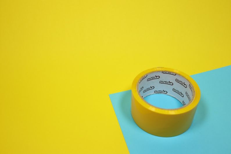 Adhesive - yellow duct tape on blue surface