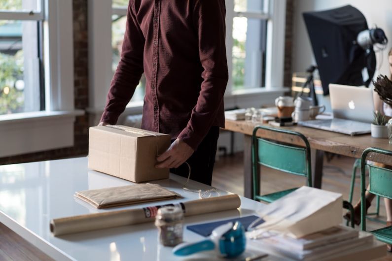 Wrapping - person holding cardboard box on table