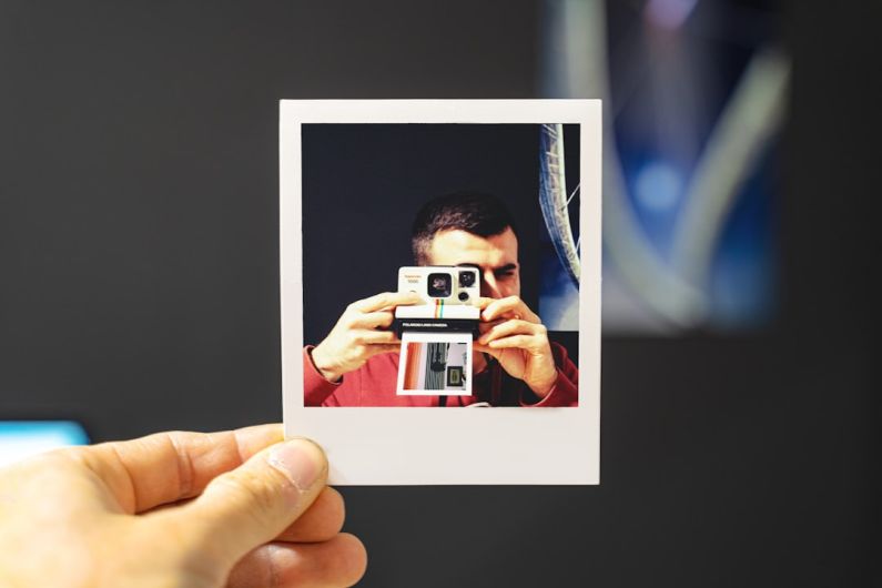 Photo Booth - person holding white and red camera